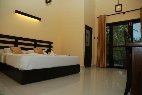 阿杭格默Charly breeze的一间卧室配有带白色床单和橙色枕头的床。