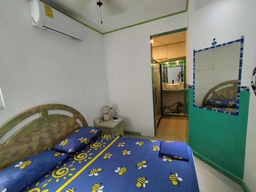 蓬塔卡纳Private Rooms-Art Punta Cana的一间卧室配有一张带蓝色毯子和蜜蜂的床