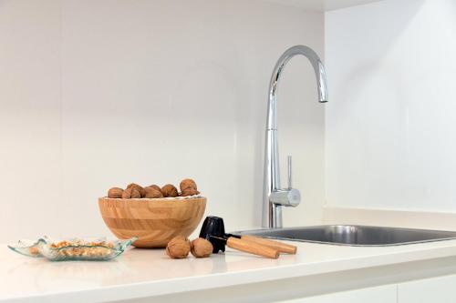 卡斯特尔德费尔斯Castell Beach Aparthotel的厨房柜台,配有一碗坚果和水槽