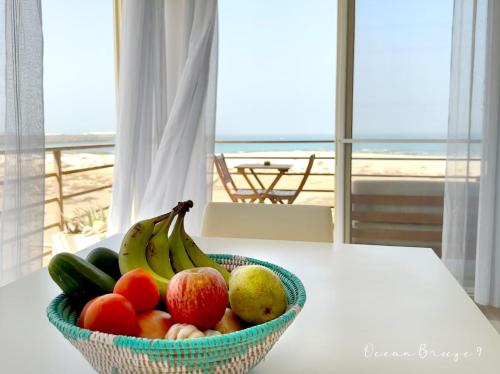 萨尔雷Ocean Breeze 9的一张桌子上的一碗水果,享有海滩美景