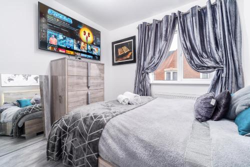 提普顿Stunning 2-Bed Apartment in Tipton Sleeps 3的一间卧室配有一张床和一台平面电视