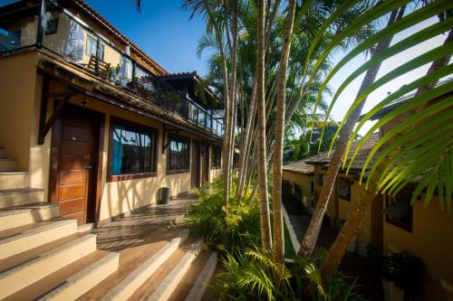 布希奥斯Hotel Barra da Lagoa by Latitud Hoteles的旁边是一座带棕榈树门廊的房子
