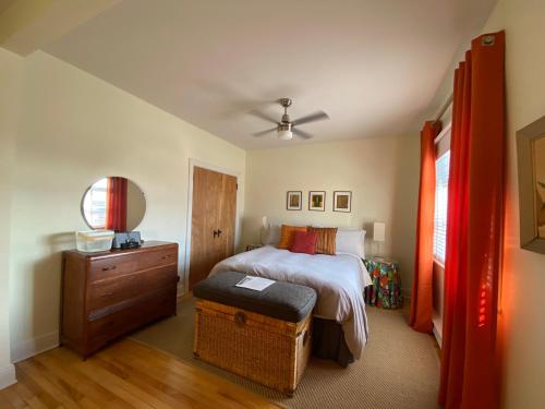 蒙特利尔Les 3 Chambres的一间卧室配有一张床、一个木制梳妆台和一张西德西德西德床