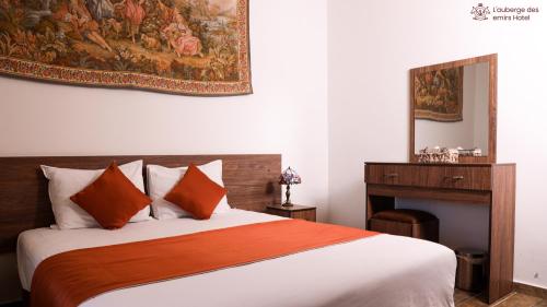 代埃尔卡马尔L'auberge des Emirs的卧室配有一张床,墙上挂有绘画作品