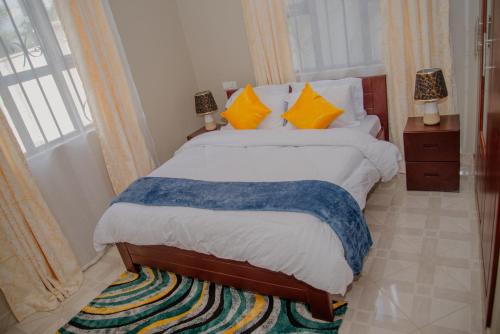 阿鲁沙Sisi's Homes的一间卧室配有带橙色和蓝色枕头的床