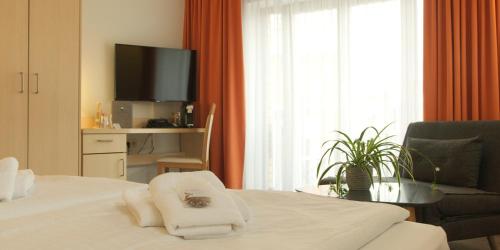 瓦伦慕特兹佩勒酒店的一间酒店客房,配有一张床和一台电视