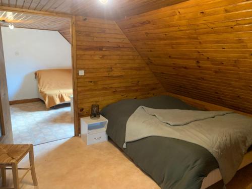 Castelnau-de-MandaillesLe Cantou的卧室配有木墙内的一张床