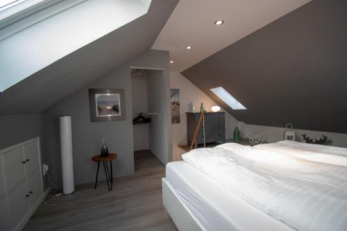 蒂门多弗施特兰德Auszeit Timmendorfer Strand的阁楼卧室配有一张白色大床