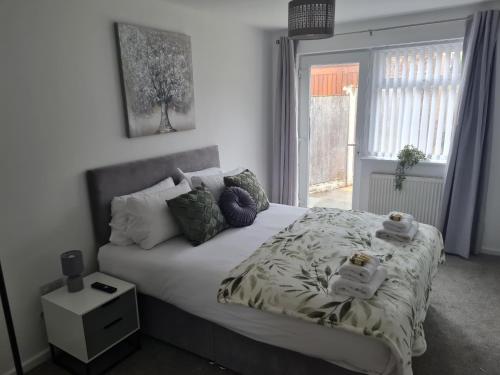 威勒尔5Bed House Wirral near Liverpool Chester的卧室配有带枕头的床铺和窗户。