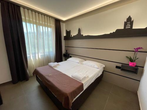 锡耶纳都耶庞蒂皇宫酒店的一间卧室设有一张床和一个大窗户