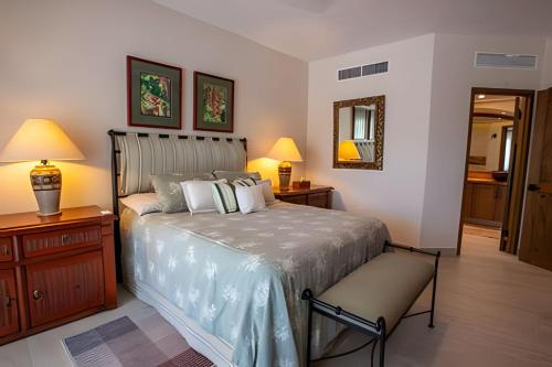 新巴利亚塔Grand Marina Villas的一间卧室配有一张床、两盏灯和一面镜子