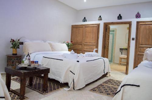 马拉喀什Ferme D'hôte Zomorroda的一间卧室配有一张床和一张桌子,上面配有毛巾
