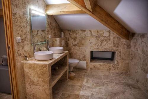 San-Gavino-di-CarbiniA PIANARELLA的一间带水槽和卫生间的浴室以及一台电视。