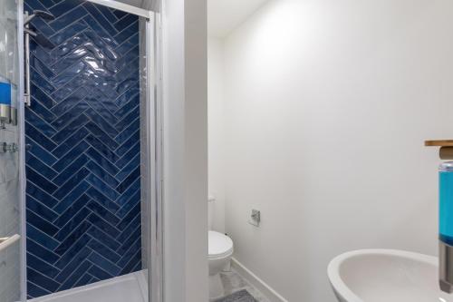 利特尔Ocean Studio Apartments的带淋浴、卫生间和盥洗盆的浴室