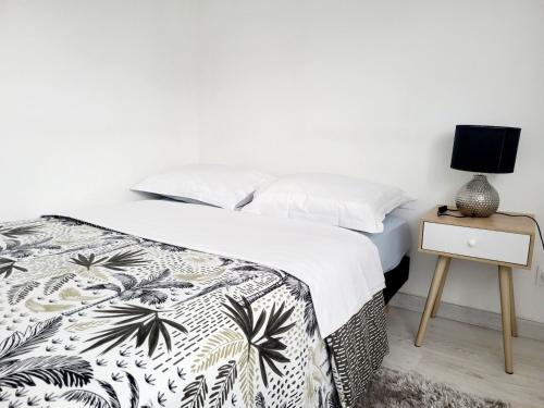摩兰吉斯Studio cosy proche Paris Orly的一间卧室配有一张床和一个带灯的床头柜