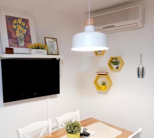 苏佩塔尔Apartment Megi in Supetar historical core的一间设有桌子和墙上电视的用餐室