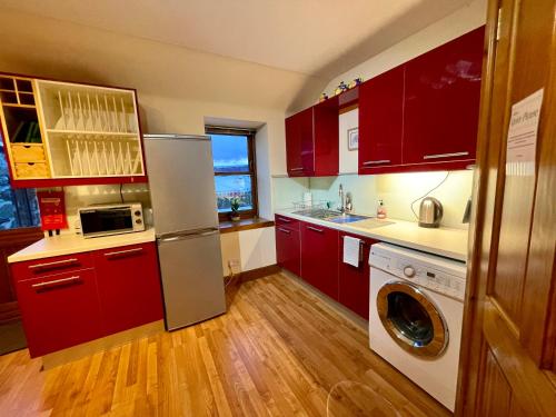 奥福德Barclay’s But n Ben的厨房配有红色橱柜、洗衣机和烘干机
