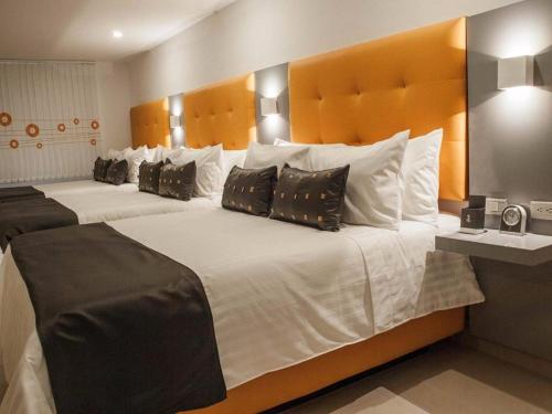 佩雷拉Hotel Dibeni Pereira的一间卧室配有两张大床和枕头