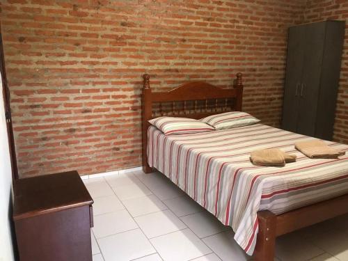 圣若昂-达巴拉Pousada Sitio Urbano的一间卧室设有一张床和砖墙