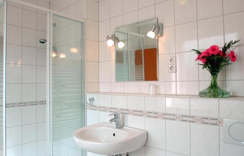 赖讷莱茵河-奥特斯塔德特德酒店的浴室设有水槽和鲜花花瓶
