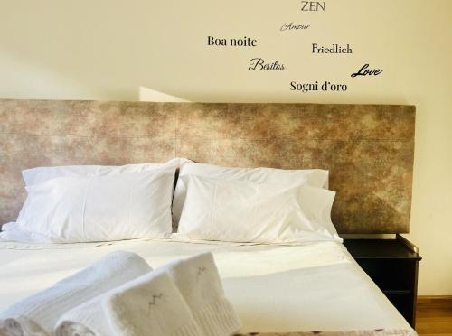门多萨La Sofia Apart & Wines的一张带白色枕头的床和墙上的文字