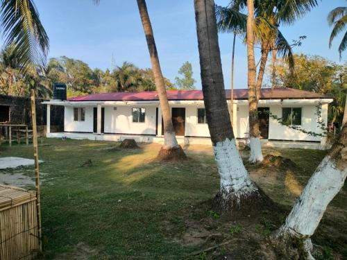 JaliapāraSurjasto Resort的前面有棕榈树的房子
