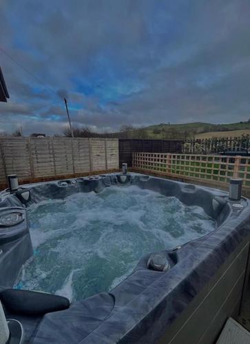 HextonThe Birch Lodge located in Pegsdon的一个带水的大型按摩浴缸