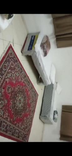 Al ‘Azīzīyahالعزيزيه الجنوبيه的一张桌子,上面有一台笔记本电脑和地毯