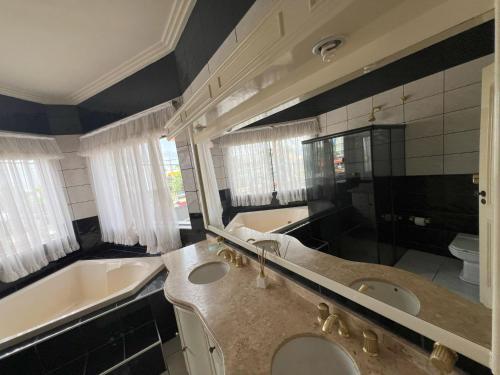 锡诺普Suíte de Luxo no centro, com hidromassagem e closet的浴室配有两个盥洗盆、浴缸和浴缸。
