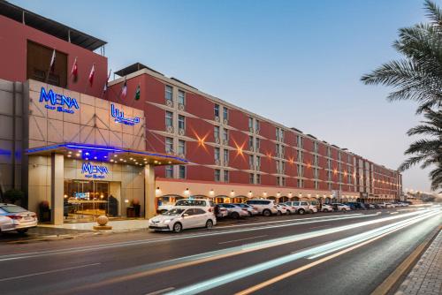 利雅德Mena Hotel Nasiriah Riyadh的停在酒店前面的一排汽车