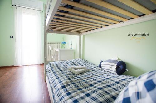 蒙特西尔瓦诺Palm Beach House - Vista mare的一间卧室配有一张带 ⁇ 子毯子的床