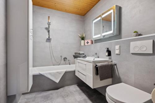 新安斯波Wohnung Weitblick的一间带水槽、浴缸和卫生间的浴室