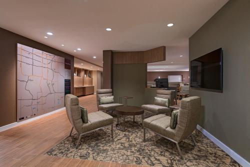 哥伦比亚TownePlace Suites by Marriott Columbia的大堂设有配备椅子和电视的等候室