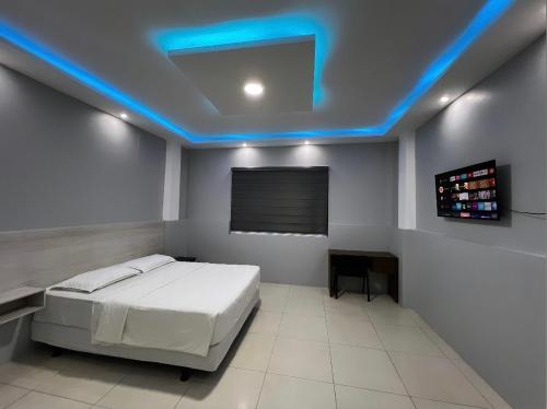 波托维耶霍Hotel KP的一间卧室配有一张床和蓝色的灯光