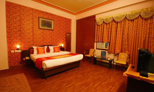 斋浦尔Hotel Manohar Palace的酒店客房,配有床和电视