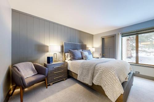 太阳谷Sun Valley Serenity的卧室配有床、椅子和窗户。