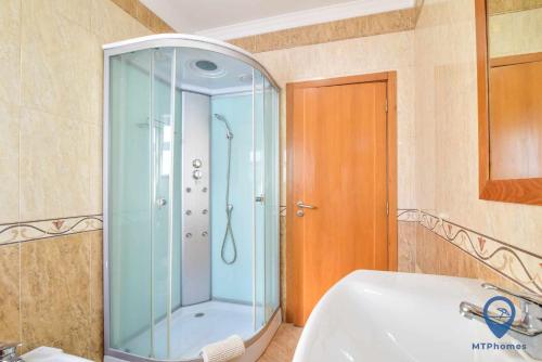 阿尔布费拉Vila Alfarrobeira的带淋浴和白色盥洗盆的浴室