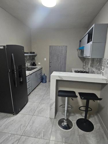 马塔莫罗斯Departamento madroño的厨房配有冰箱和2个吧台凳