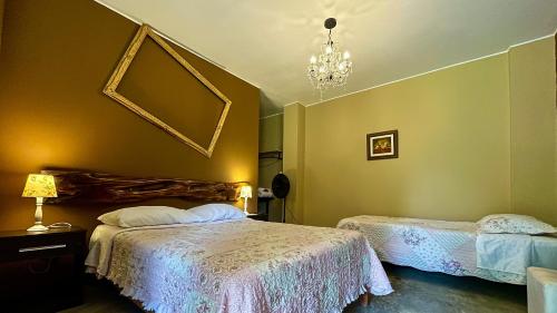 伊察Serenity hotel & lodge的一间卧室配有两张床和吊灯。