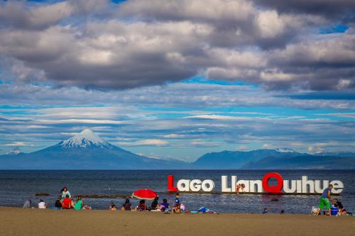 延基韦Casa LLanquihue的一群人,在海滩上,以山为背景