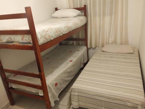 瓜鲁雅Casa com piscina, enseada Guarujá sp.的一间卧室配有两张双层床和一张床垫