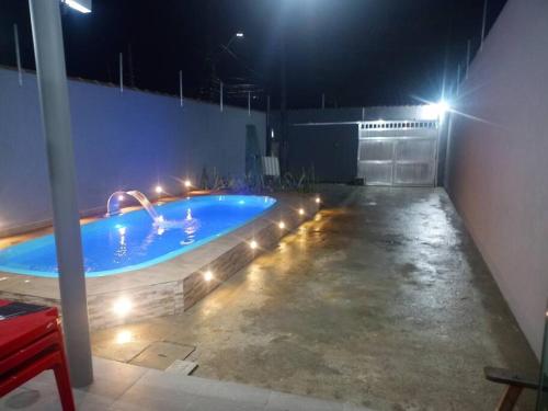 瓜鲁雅Casa com piscina, enseada Guarujá sp.的大楼内带灯的大型游泳池