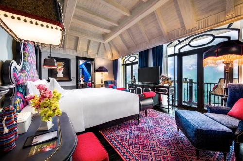 萨帕Hotel de la Coupole - MGallery的酒店客房,配有一张床、一张桌子和椅子
