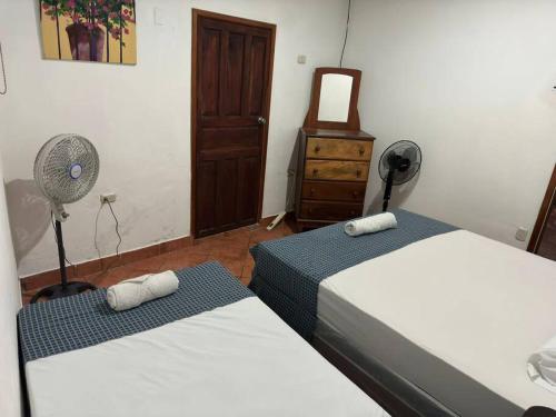 格拉纳达Apartamento Nilxon的一间卧室配有两张床、风扇和梳妆台