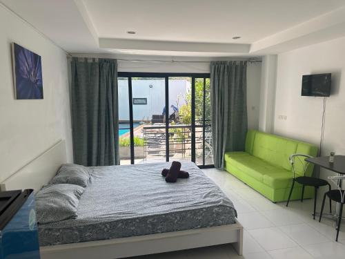 苏梅岛Infinity Bo Put Apartment的一间卧室配有一张床和一张绿色沙发