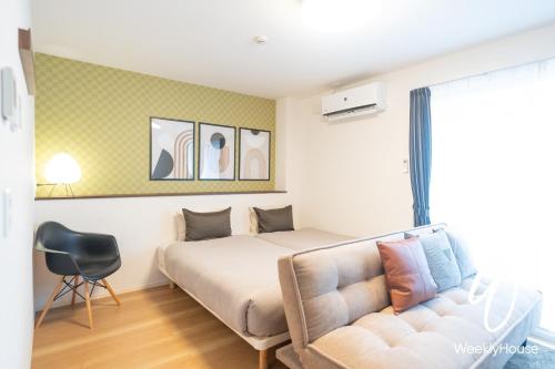 大津WeeklyHouse Silto Crete - Vacation STAY 61955v的一间卧室配有一张床和一张沙发