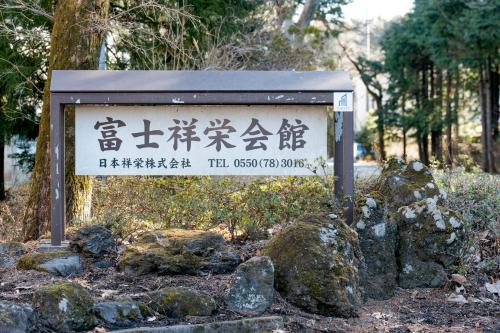Oyama富士祥栄会館的岩石和树木前的标志