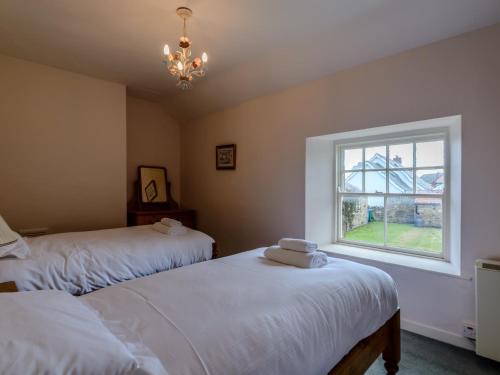 比德内尔2 Bed in Beadnell 66483的一间卧室设有两张床和窗户。