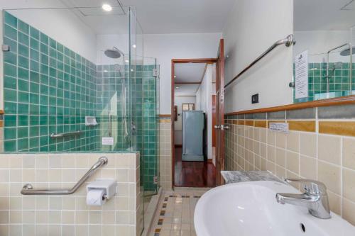 曼谷品考查理豪斯酒店的一间带水槽和玻璃淋浴的浴室