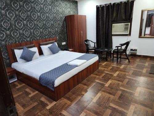 新德里Hotel New City Lite的卧室配有一张床和一张桌子及椅子